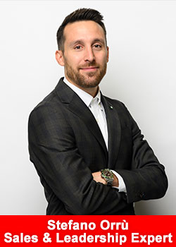 Professional portrait of Stefano Orrù, sales and leadership expert, standing with arms crossed